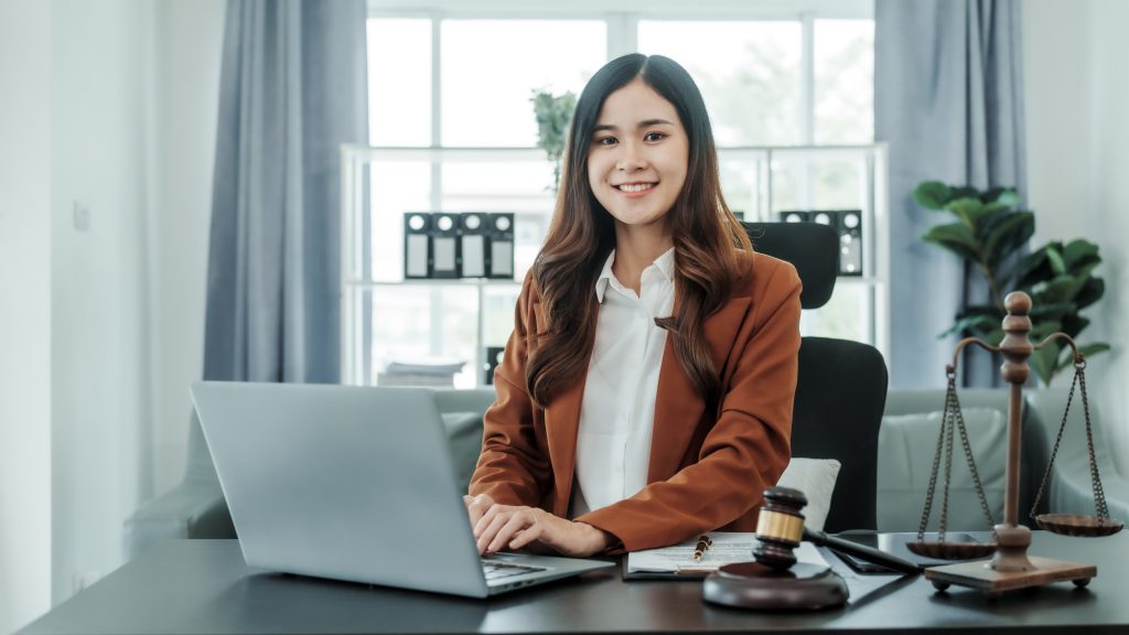 Looking camera, Online consulting with laptop in office of asian thai japanese chinese female exclusive lawyer legal advisor, legislation, saleswoman, legal contract documents