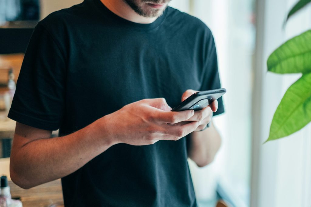 man in a black shirt holding a phone