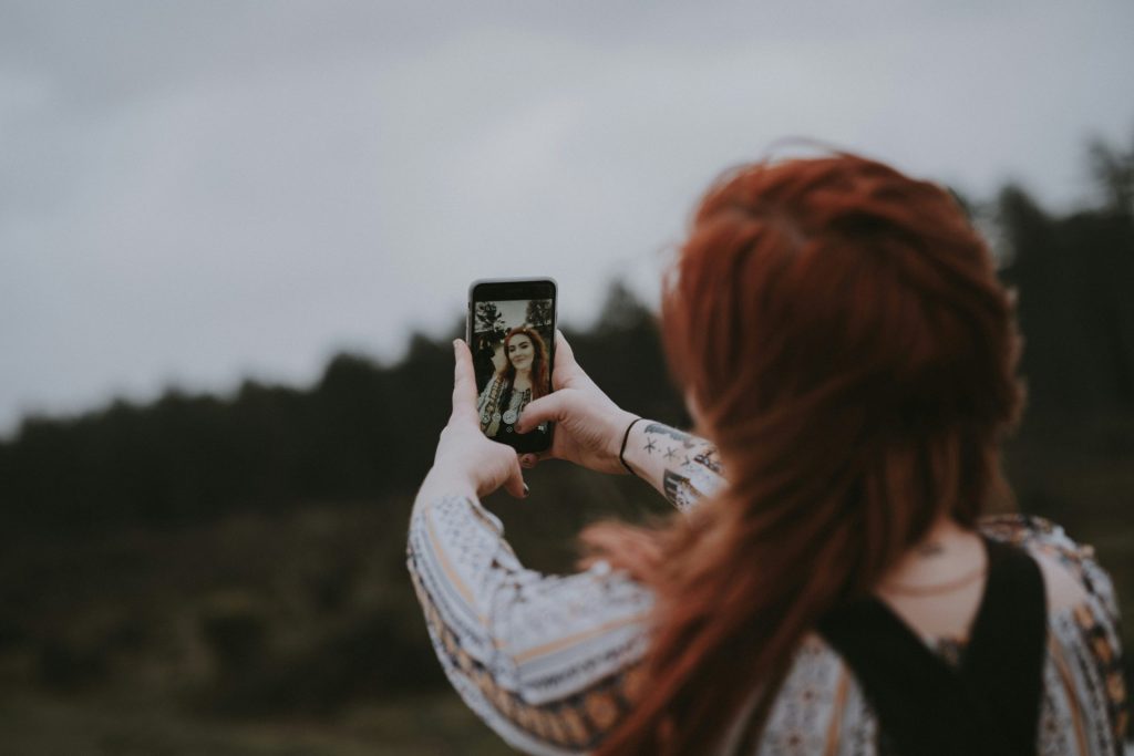 woman filimg herself with phone