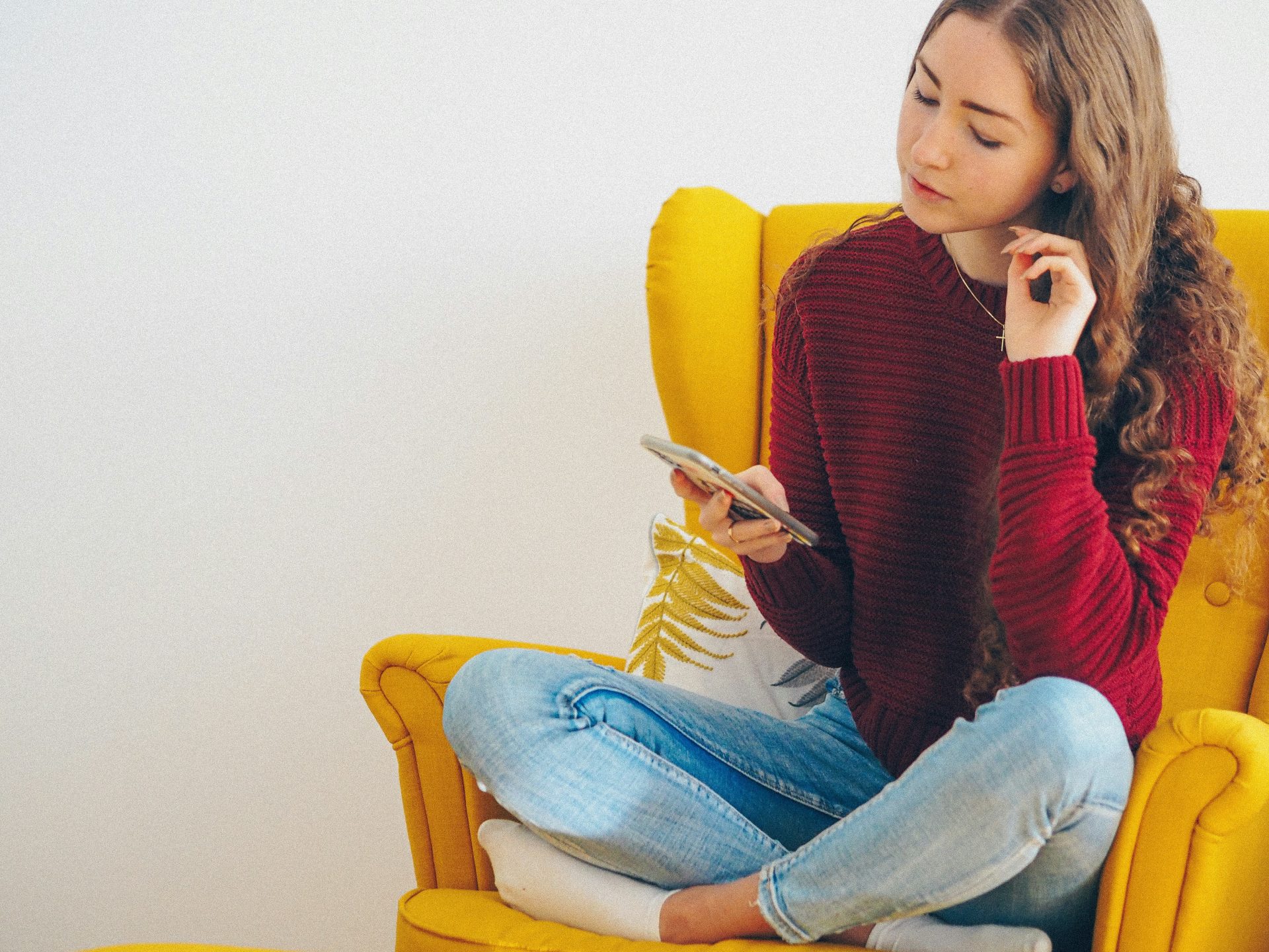 woman in a red hoodie sitting in a yellow chair