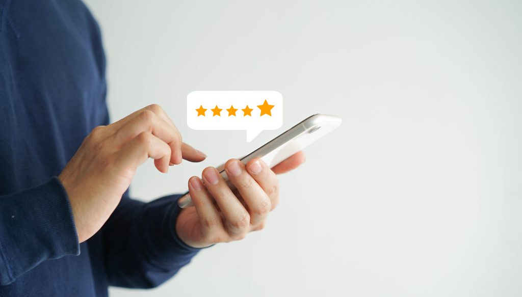 close up on customer man hand pressing on smartphone screen with gold five star rating feedback icon and press level three rank (good) for give score point to review the service business concept