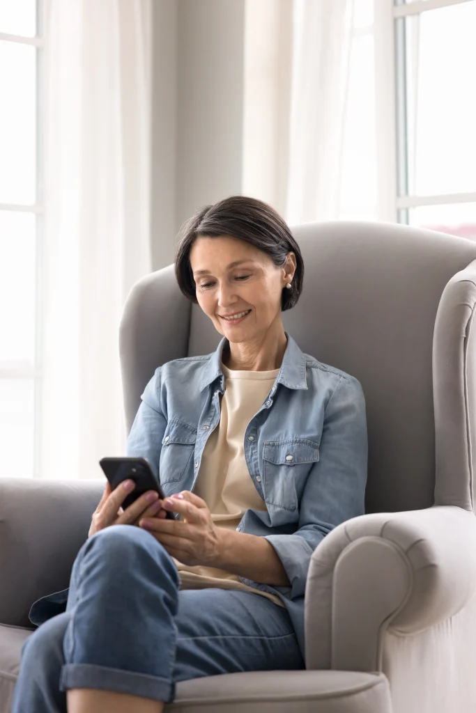 woman sitting in a chair looking at her phone