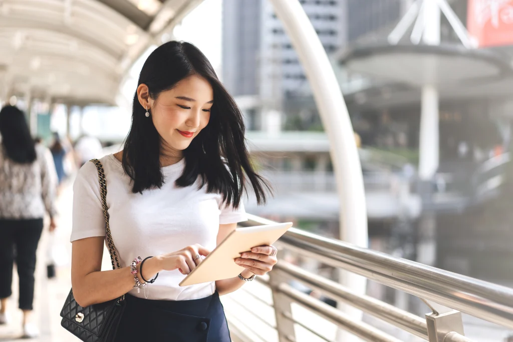 woman on a bridge looking at her tablet